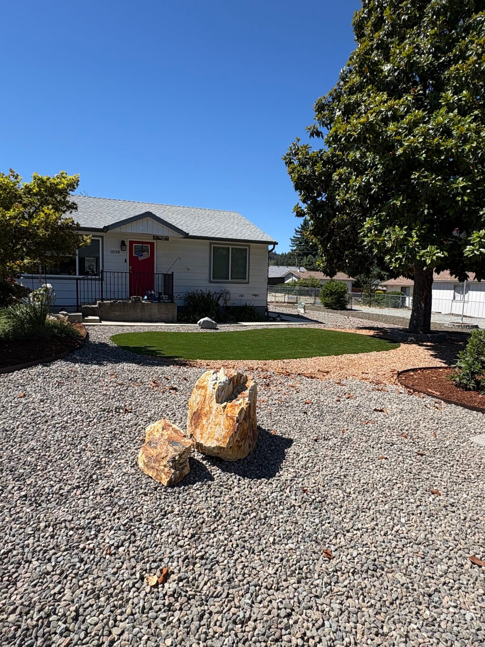 Front yard turf installation with boulder accent