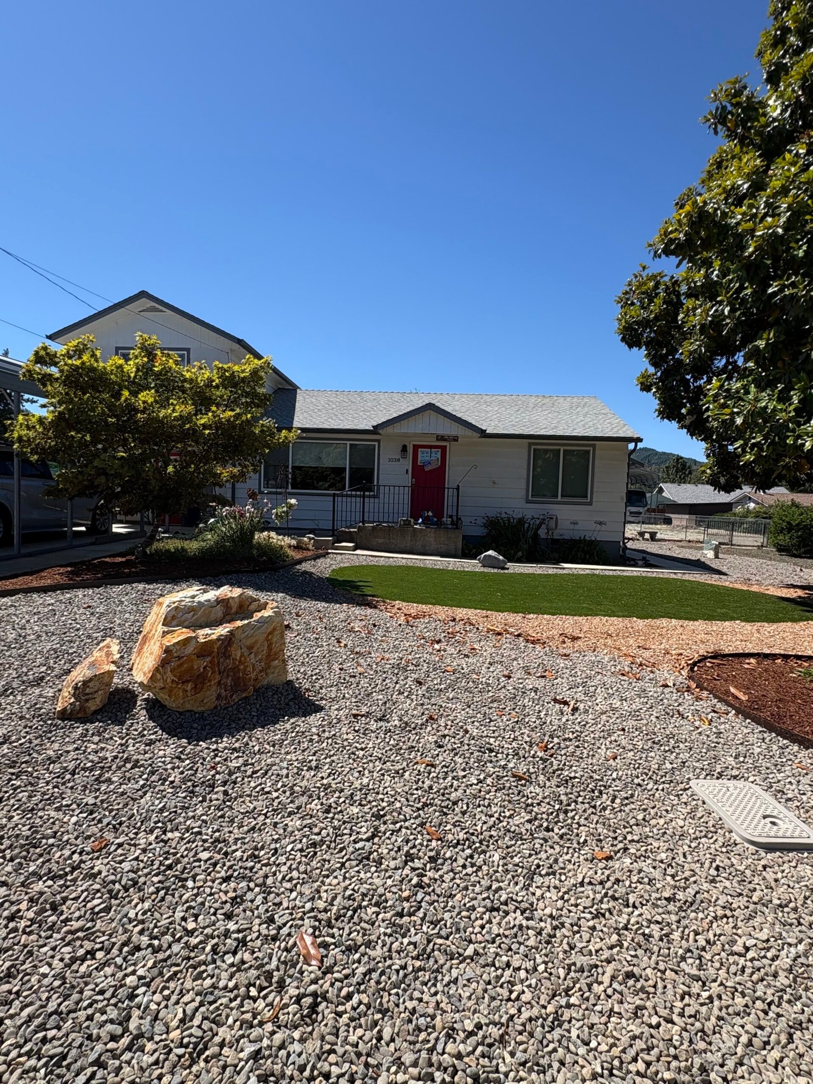 Front yard artificial turf with boulder accent